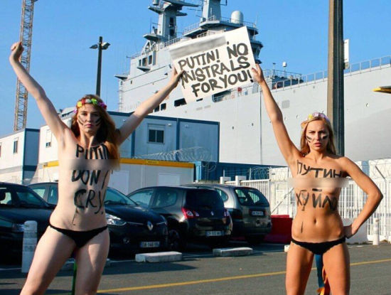 资料图:9月10日,两名乌克兰女权团体“FEMEN”的成员在法国为俄罗斯建造的西北风级两栖攻击舰前抗议普京。