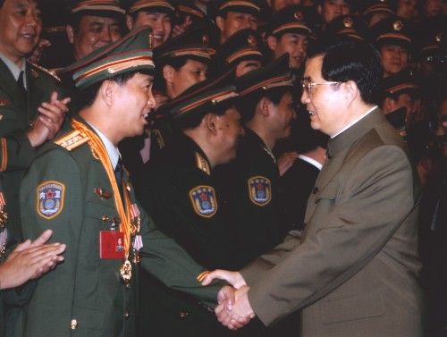 2005年6月22日,时任中共中央总书记、国家主席、中央军委主席胡锦涛与独臂英雄丁晓兵亲切握手。(资料图/新华社)