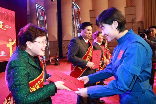航天员刘洋(右)为获奖家庭代表颁奖 李新健摄