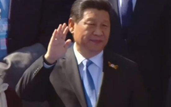 习近平主席向解放军仪仗队挥手致意。
