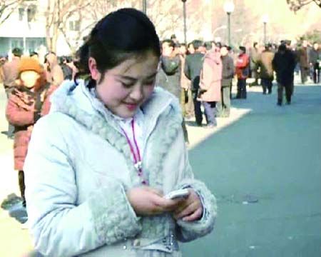 一位平壤姑娘在玩手机·