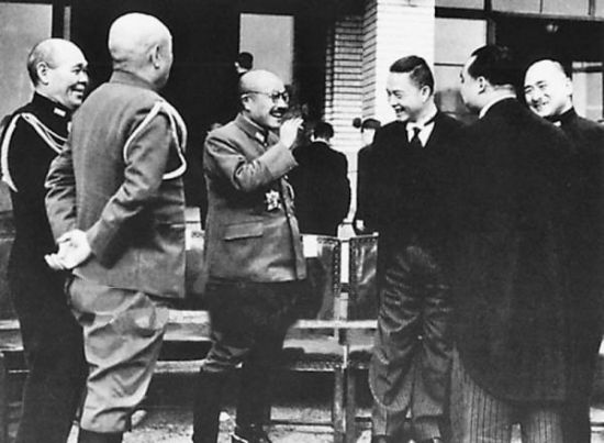 1942年12月,日军扶植的伪“南京国民政府主席”汪精卫(右三)前往东京,参加“大东亚战争一周年纪念会”。图为汪精卫会见东条英机(左三)时的情形,东条英机抽着烟,得意之色溢于言表。
