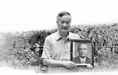 廖品正拿着的是父亲廖季威的遗像。