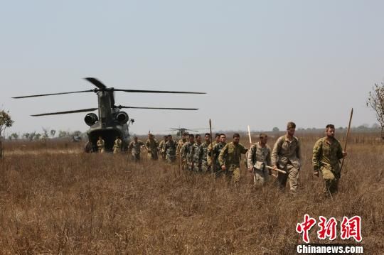 中澳美三国士兵排成一个单人列队走下飞机。赖海隆 摄
