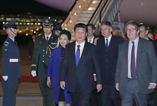 习近平和夫人彭丽媛在机场受到英国女王代表胡德子爵、外交大臣哈蒙德等热情迎接。