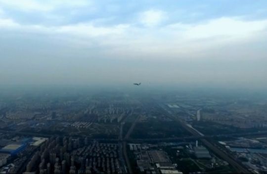 一架遥控操作的多旋翼无人机正在我国某城市上空数百米悬停拍摄,画面右侧突然高速飞入一架已经放下前三点式起落架的双座喷气式飞机,疑似正在进入进近着陆阶段。
