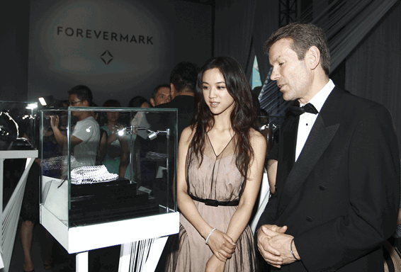 (ForevermarkTM永恒印记全球营销Dominic Brand先生与国际巨星汤唯小姐(从右至左)欣赏“A Promise Shared分享承诺”之“承诺系列”甄选钻饰展) ForevermarkTM永恒印记全球营销Dominic Brand先生与国际巨星汤唯小姐