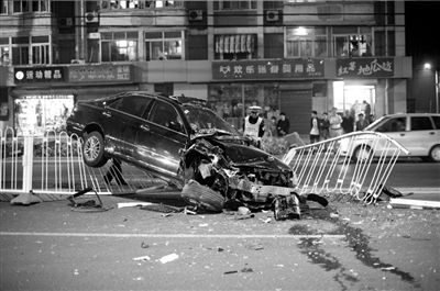 皇冠车失控骑上护栏 车内两人受伤