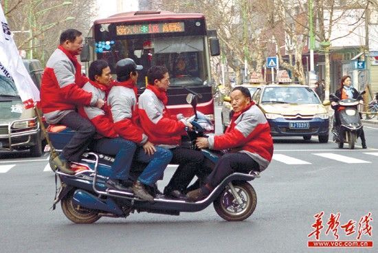 5名男子挤1辆电动车在街头行驶引围观