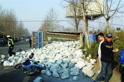 大货车为躲车侧翻 车上石块埋住两名市民