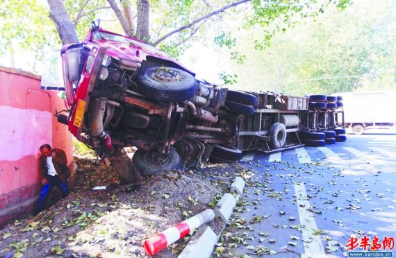 大货车撞在树上侧翻在路边。