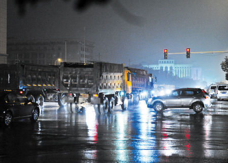 昨晚10时23分，福元西路和芙蓉北路交会处，三辆渣土车闯红灯，右侧按信号灯正常通行的车辆反而被拦住了。 王志伟 摄