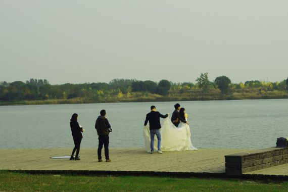 在南湖边拍婚纱照的一堆新人