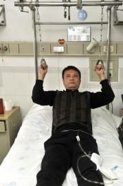 刘军如今已能下地行走，他每天都要在床上拉环锻炼肌肉。