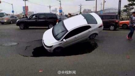 公路突现塌陷大坑将一辆小轿车吞没