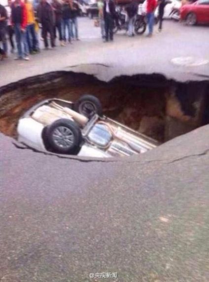 公路突现塌陷大坑将一辆小轿车吞没