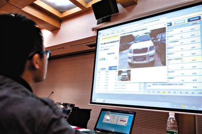 2014年12月2日，深圳市直机关公务用车改革车辆拍卖会举行，工作人员在拍卖会上查看拍卖结束车辆。新华社记者 毛思倩 摄