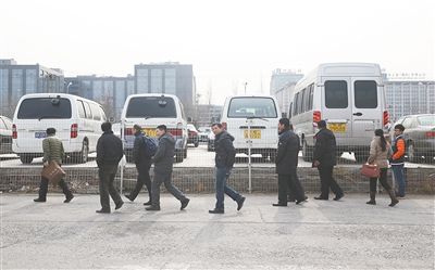 2015年2月1日，北京旧车市场东厅。人们围着待拍车辆观看，为参加拍卖做功课。2月1日下午，“公车拍卖”第三场在北京旧车市场东厅举行。 新京报记者 尹亚飞 摄