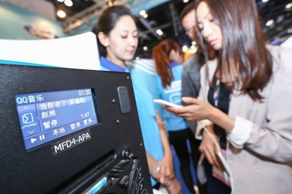 在2015全球移动互联网大会福特展台上，观众体验智能手机应用程序与福特AppLink平台相连接