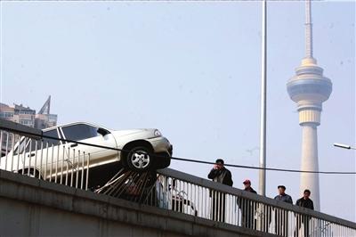 起亚轿车违规连并两条车道 被公交车顶上护栏