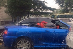 男子雨中淡定开敞篷车 土豪的世界你不懂