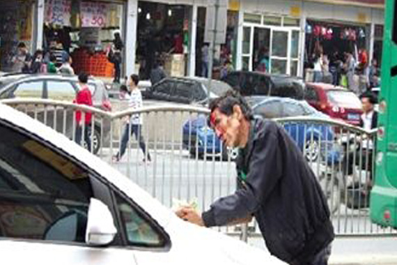 乞讨男子脸上抹血拦车要钱 不给不让走