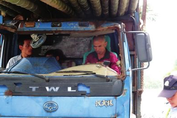 超载货车挡风玻璃被压坏 司机拿雨伞顶岗