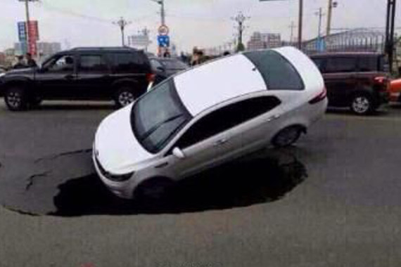 公路突现塌陷大坑将一辆小轿车吞没