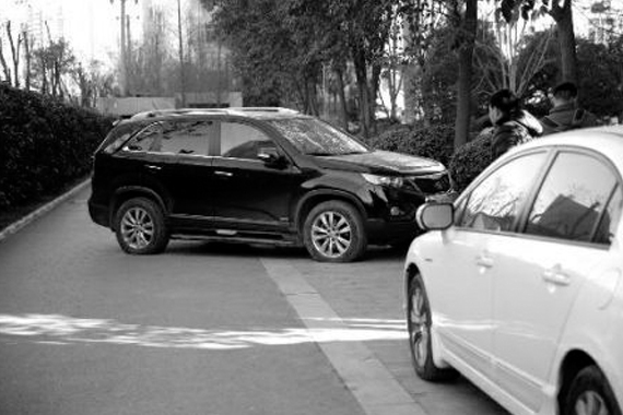 车主因轮胎被扎物业不管 用车堵小区道路