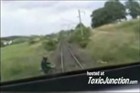 视频：摩托车手在道口上与火车头擦身而过