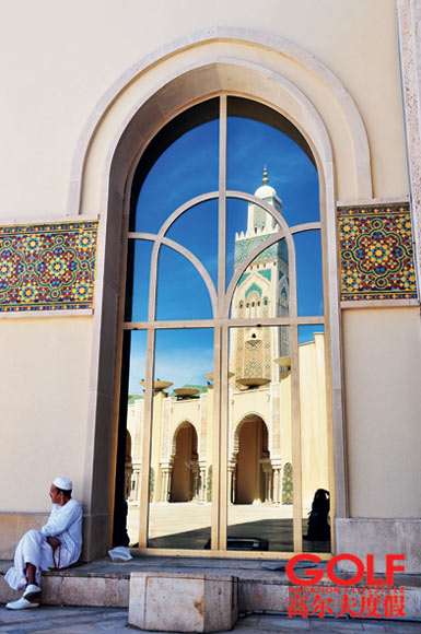 哈桑二世清真寺前,一位等待开门的穆斯林游客。玻璃中发射出的宣礼塔显得格外高大。 哈桑二世清真寺前,一位等待开门的穆斯林游客。玻璃中发射出的宣礼塔显得格外高大。