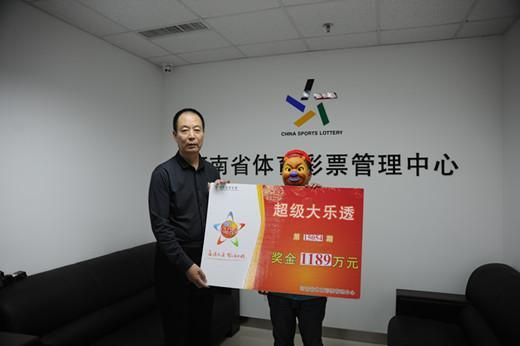 河南省体彩中心主任孙和平(左)为大奖得主颁奖