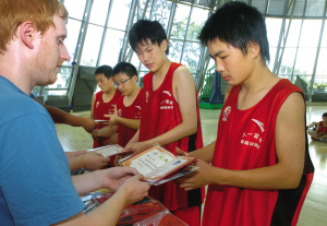 图为教员在向学员发放毕业证书. 记者 周一 盛高 摄影报道