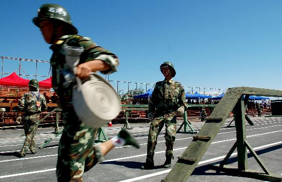 文-新疆举行消防运动会 100米消防障碍赛跑比