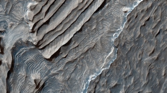 贝克勒尔陨石坑（Becquerel Crater）坑底的浅色多层沉积物。贝克勒尔陨石坑位于火星北半球的“阿拉伯地”（Arabia Terra）地带。沉积物由始终只有几米厚的成堆岩体构成。沉积物表面看上去也裂成了一块块长1米左右的片段。