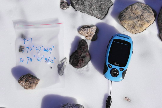 这是12月30日拍摄的中国第26次南极考察格罗夫山队队员发现的陨石(画面中央黑色石块)。