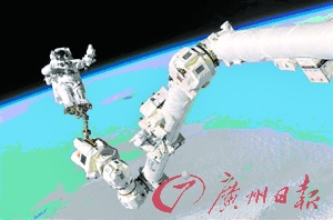 宇航员双脚被固定在国际空间站上的自控臂上，进行舱外活动。