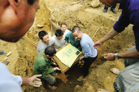 挖掘人员从墓室中挖出墓志 