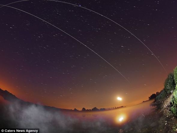 在这张图里可以看到，轨道里的国际空间站产生的两道运行轨迹弯向地球方向