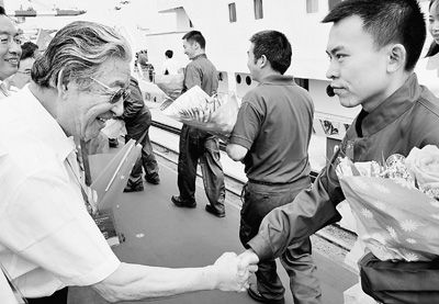 图为蛟龙号载人潜水器总设计师徐芑南研究员(左)为潜航员们壮行。