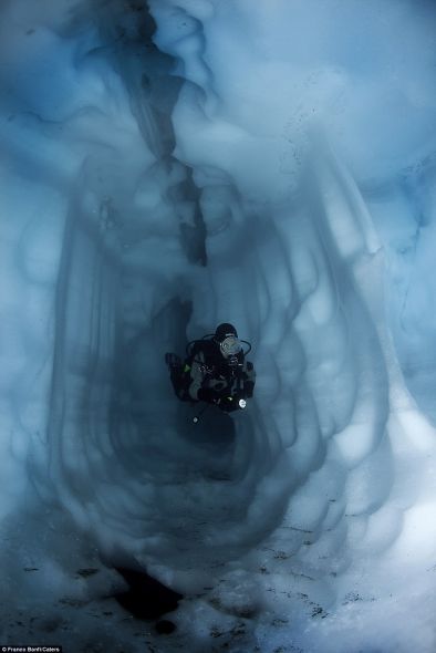 一名潜水者在通道中穿行。通道位于瑞士索罗湖的一条冰川下面，由温度变化形成