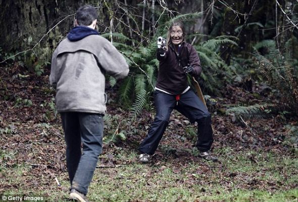 　　摆脱食肉动物世界：乔思林-摩尔（右）利用一把玩具手枪袭击俄勒冈州桑迪的僵尸，这是为期两天的谋杀僵尸课程的一部分