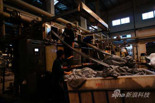 工人将布匹放入机器