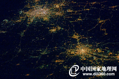 　　航拍京津“不夜城”2010年12月，美国国家航空航天局官方发布了一幅令人吃惊的太空照片。国际空间站的航天员将镜头对准了中国华北地区。照片中，北京和天津的城市夜景一览无余，道路照明轮廓十分清晰，夹在两城之间的廊坊以及东北部几个开发区也有明亮的灯光。图中黑色区域主要是农田。供图／NASA
