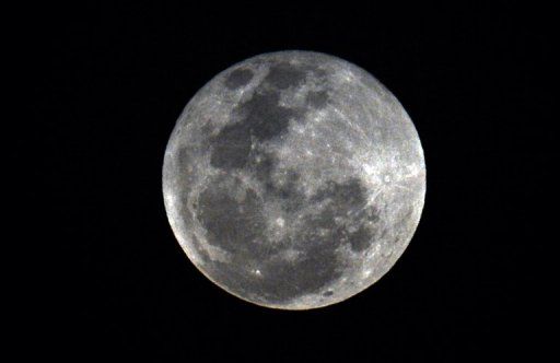 　　2013年4月25日晚拍摄的巴拿马城上空的皓月当空。一项最新研究显示，月球上一部分陨坑内部的物质可能是撞击月球的小天体的残留物，而非长期以来人们认为的那样是由于撞击作用暴露出来的月球内部物质