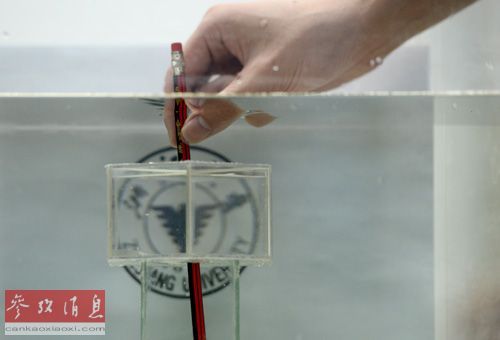 　　10月31日，浙江大学陈红胜教授研究团队工作人员演示一件“隐身”装置的效果。当一支铅笔被放入该装置中时，铅笔的中间部位“不见了”，但该部位的背景图案仍然可见。新华社记者韩传号摄