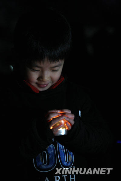 韩国首都首尔，一名儿童手捧蜡烛参加“地球一小时”活动