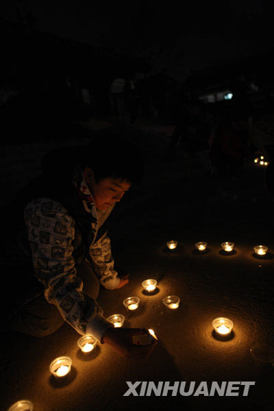 韩国首都首尔，一名儿童手捧蜡烛参加“地球一小时”活动