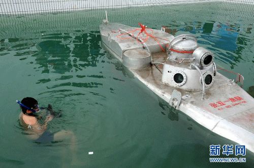 5月8日，一位记者在水里拍摄张五一自制的“潜艇”
