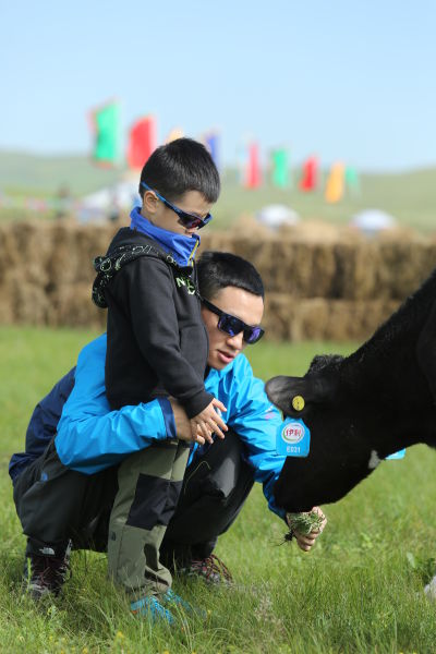 杨威抱着杨阳洋喂牛